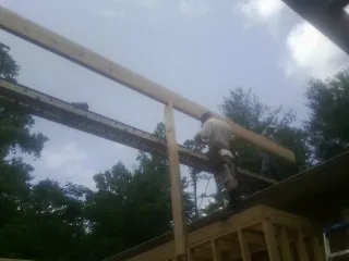 Carpenter setting a ridge beam over a new addition frame — Ice Dam Removal by Roofing Brothers in Altamont